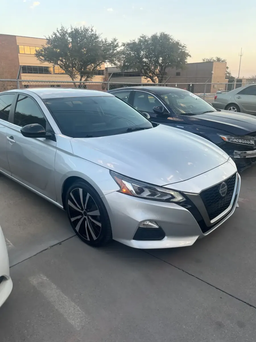 A clean silver Nissan Altima in the shop lot