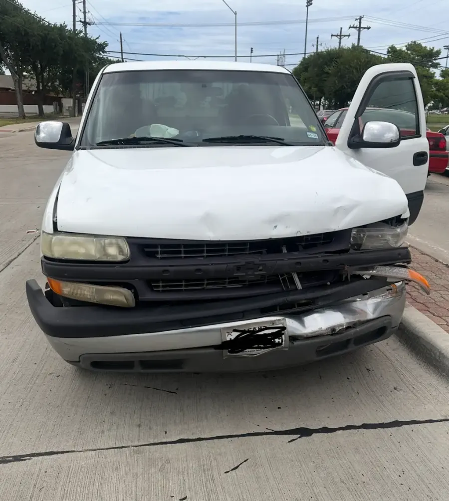 A white pickup truck with front end collision damage